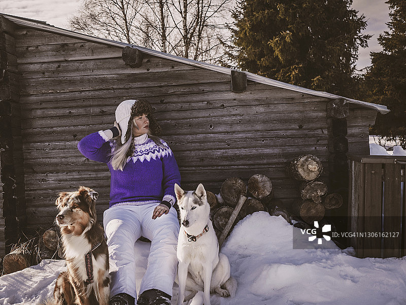 女人和狗在木棚前放松图片素材