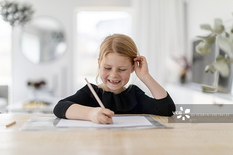 女孩在桌旁做功课图片素材