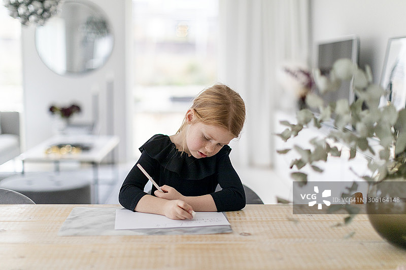 女孩在桌旁做功课图片素材