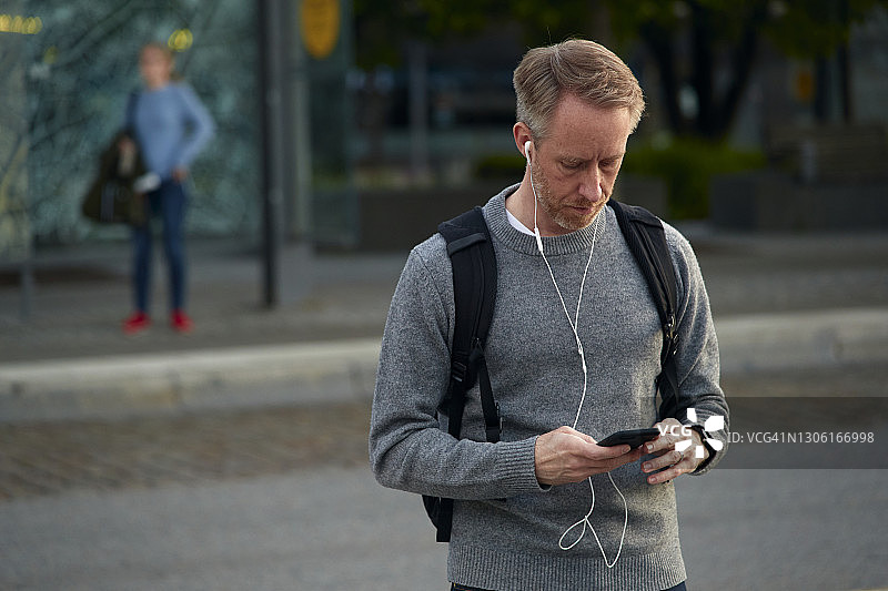 在街上拿着电话的男子图片素材