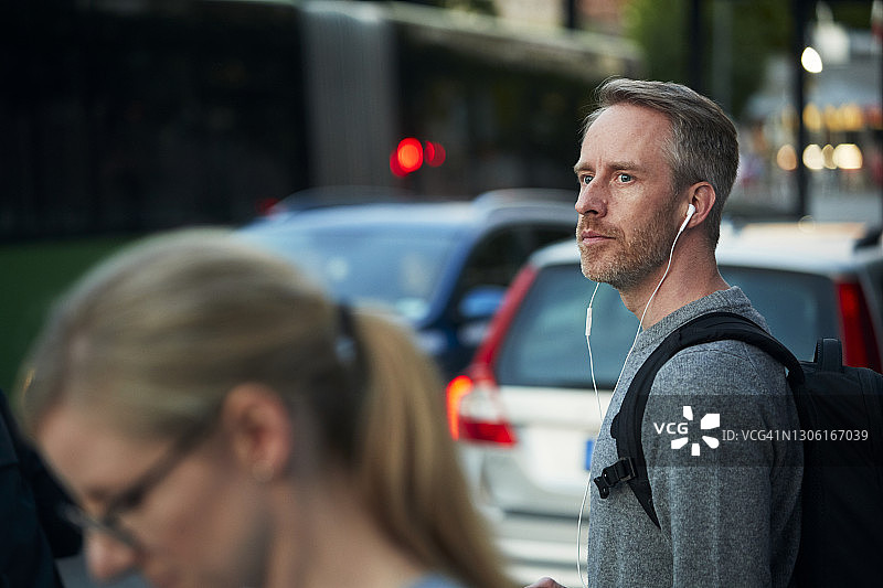 戴着耳机向远处看的男人图片素材