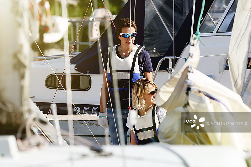 两个年轻女人穿着救生衣在帆船上图片素材