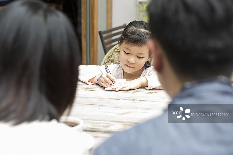 在咖啡馆里交谈的快乐亚洲家庭图片素材
