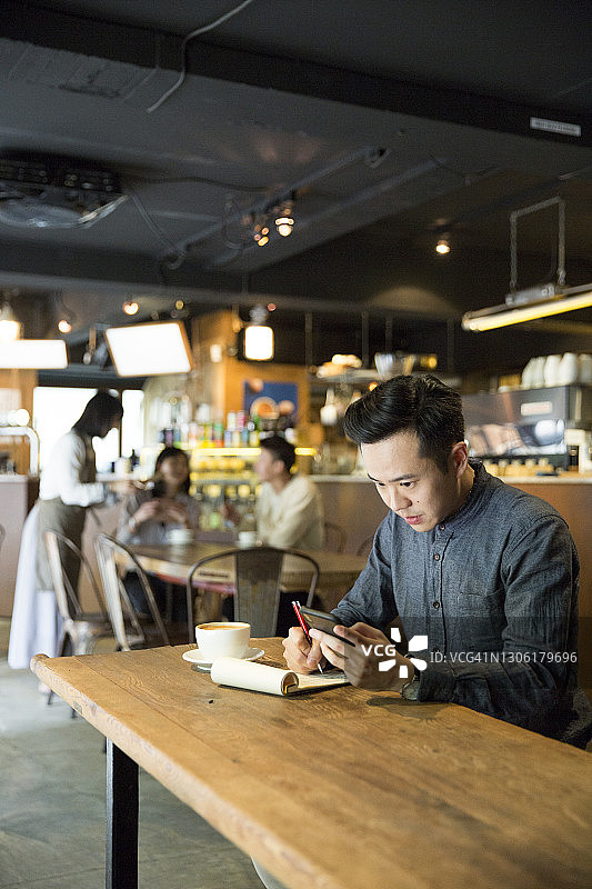 咖啡馆店主在桌旁计算业务图片素材