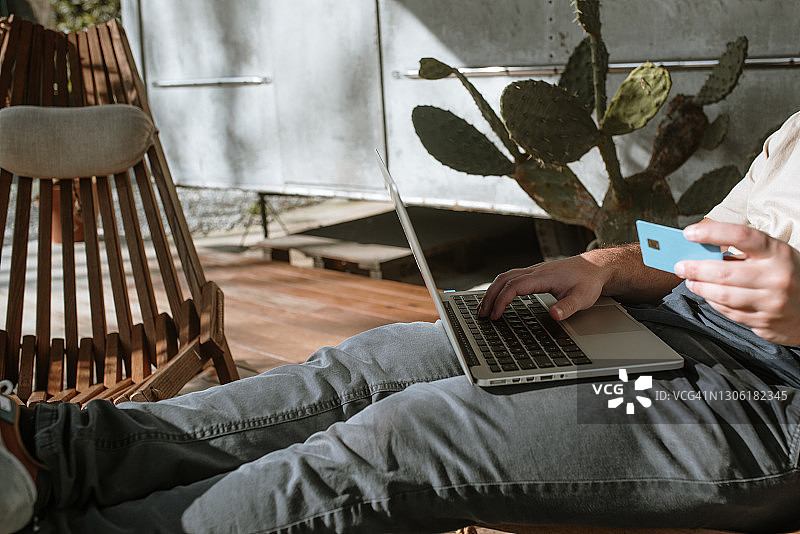 用信用卡在线购物的年轻男人图片素材
