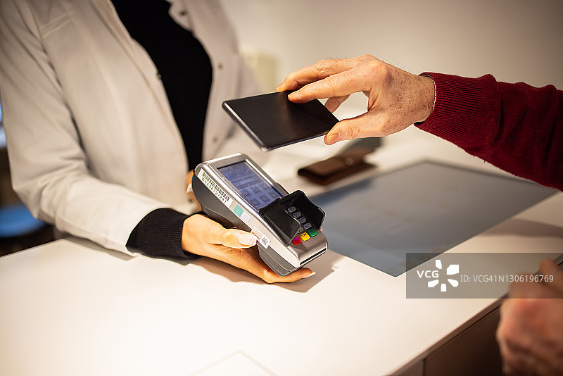顾客在眼镜店进行非接触式支付图片素材