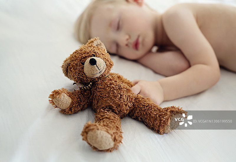 小男孩抱着泰迪熊睡觉图片素材