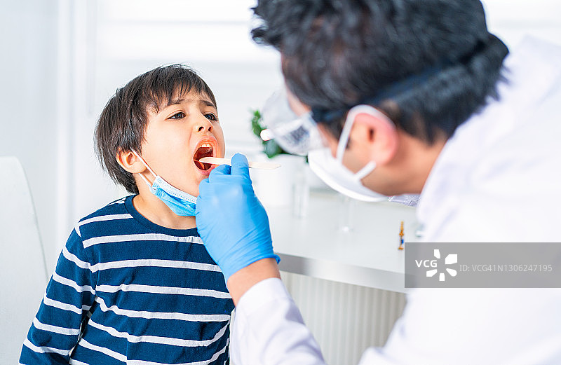 男性儿科医生在诊所检查小患者的喉咙图片素材