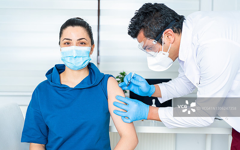 疫情期间在诊所接种疫苗的年轻女人图片素材