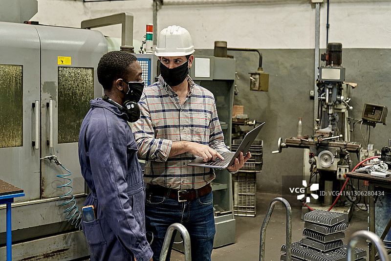 新冠疫情期间的工头和金属工人交谈图片素材