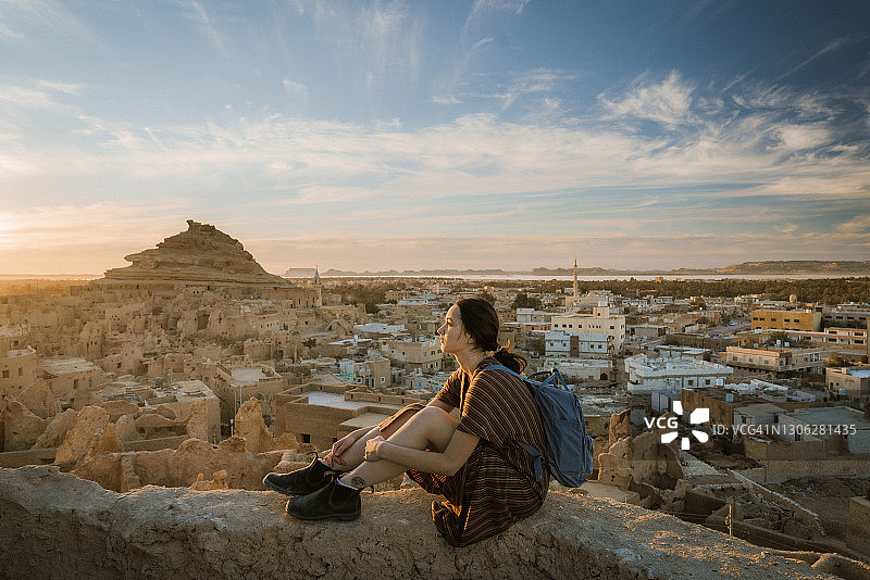 女人在日落时欣赏锡瓦绿洲的风景图片素材