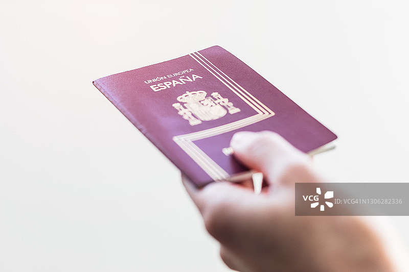 手持西班牙护照，白色背景图片素材