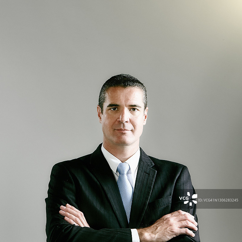 穿着时尚西装的交叉双臂男商人图片素材