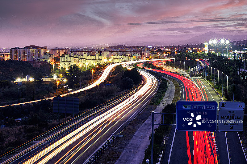 日落时繁忙高速公路上的汽车光轨图片素材