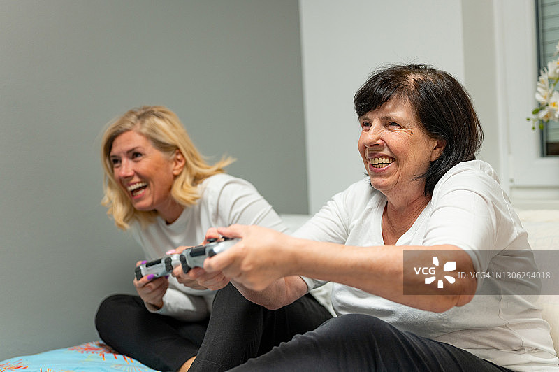 老年人和成年女人在家玩电子游戏图片素材