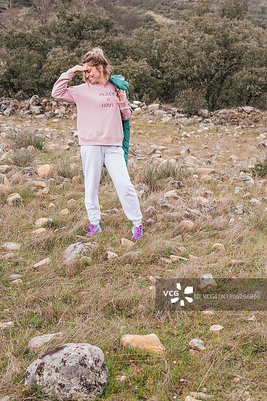 在田野里穿着运动服摆姿势的迷人女性图片素材