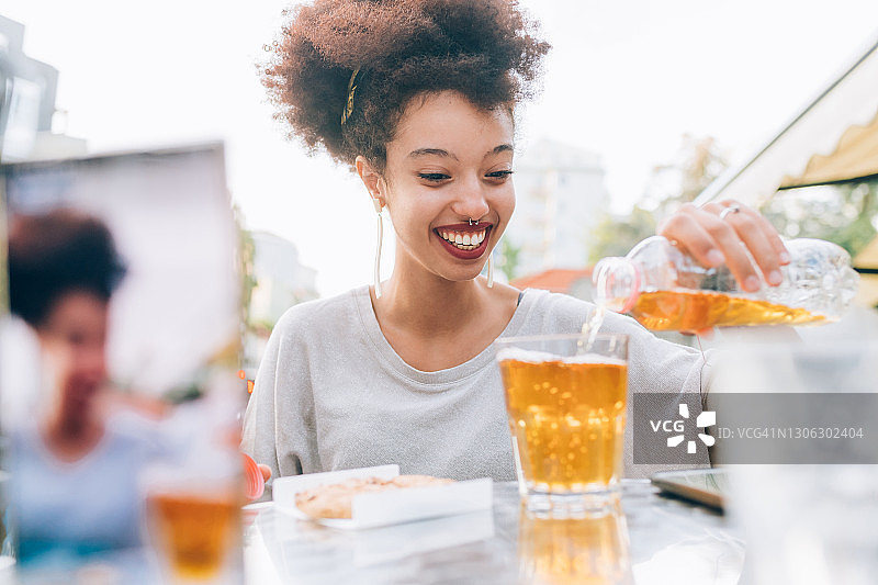 年轻女人在户外咖啡馆倒饮料图片素材