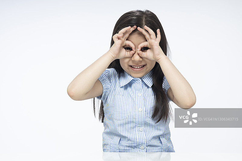 坐在白色背景上的印度可爱女童肖像图片素材