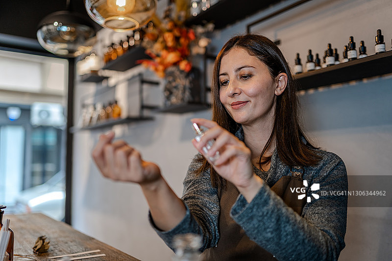 年轻的调香师在自己的店内配制香水图片素材