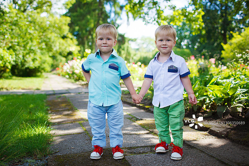 可爱双胞胎小兄弟花园漫步图片素材