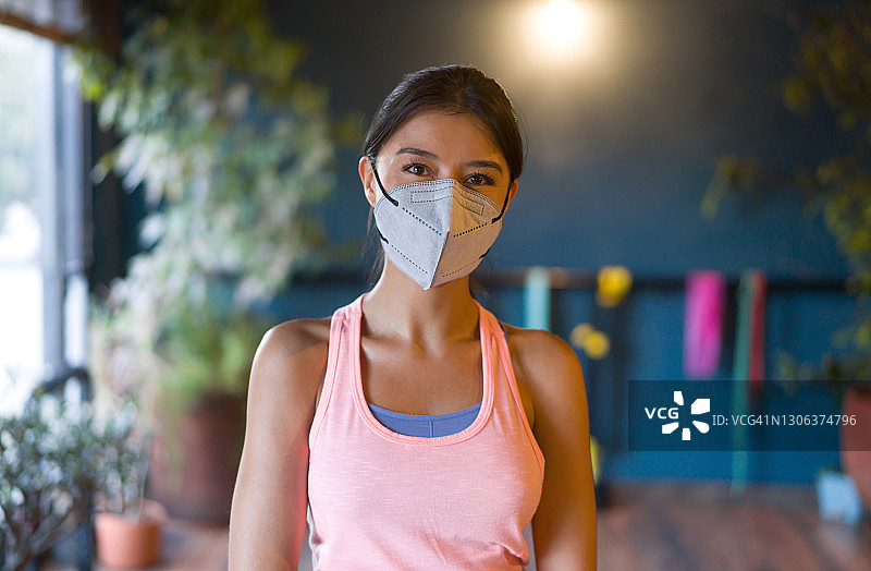 快乐的女人在健身房戴着口罩图片素材