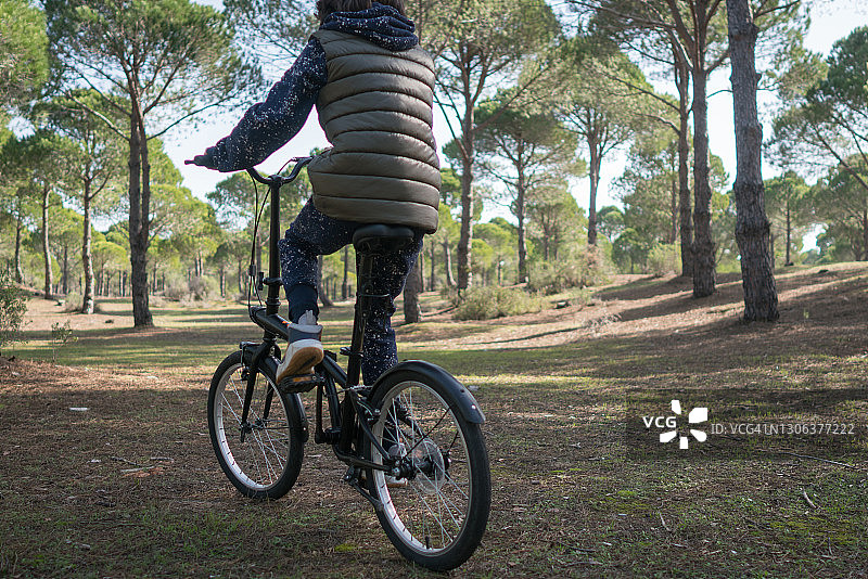男孩在森林里骑自行车图片素材