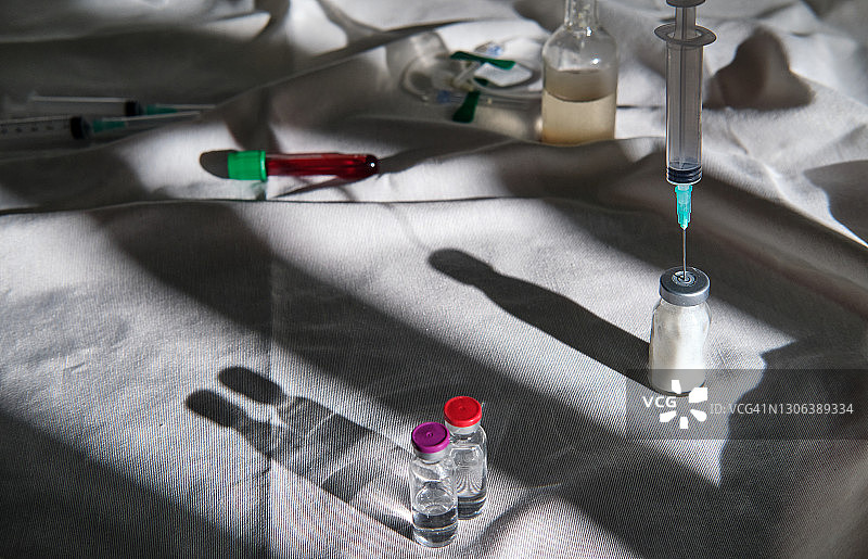 灰色桌布上的疫苗瓶和注射器图片素材