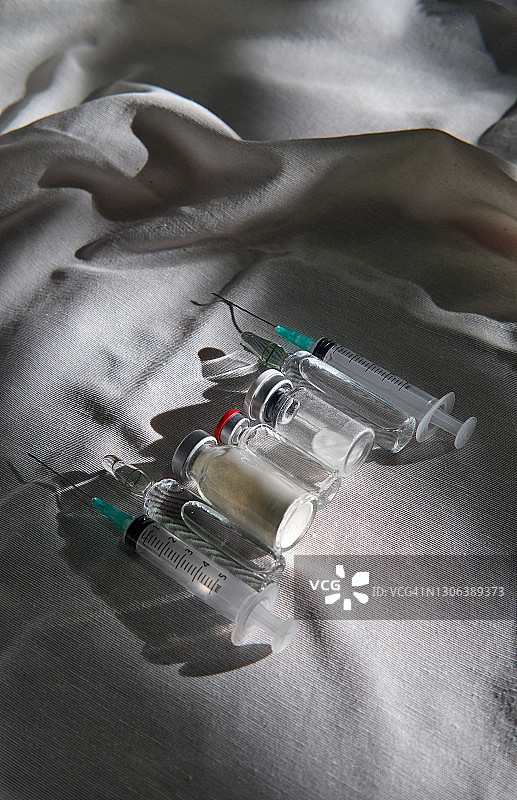 灰色桌布上的疫苗瓶和注射器图片素材