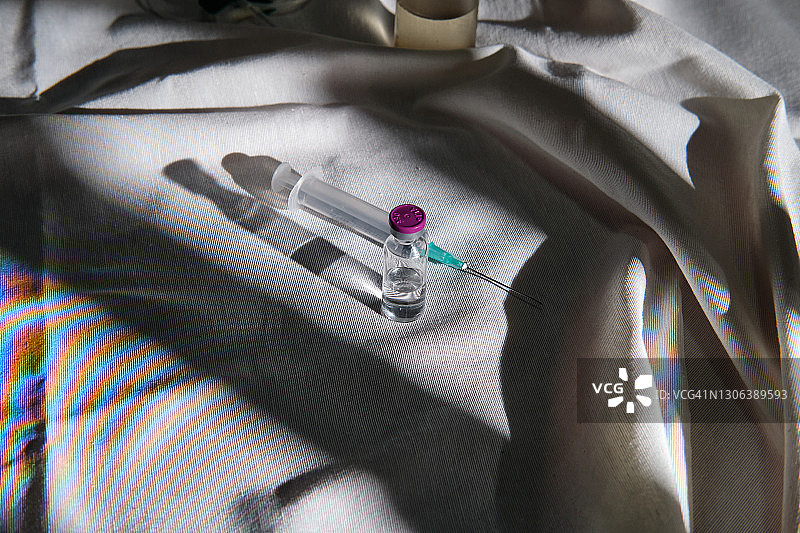 灰色桌布上的疫苗瓶和注射器图片素材