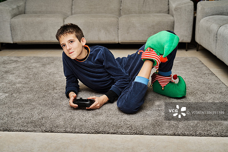 专注的男孩手持遥控器玩电脑游戏正面照图片素材