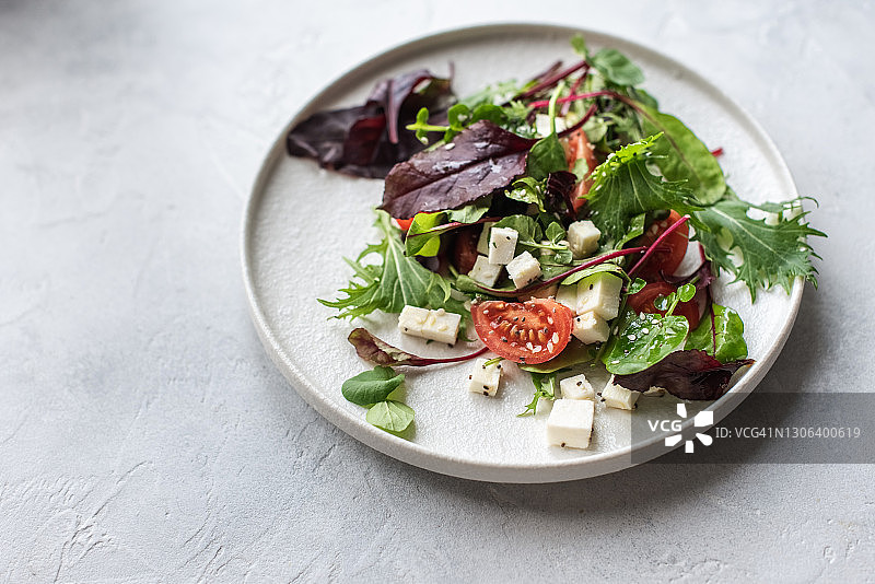 塔布勒沙拉、盘子、乡村混凝土背景。传统中东或阿拉伯菜肴。黎凡特素食沙拉配欧芹、薄荷、布格麦、番茄。中东mezze的一部分。文本空间图片素材