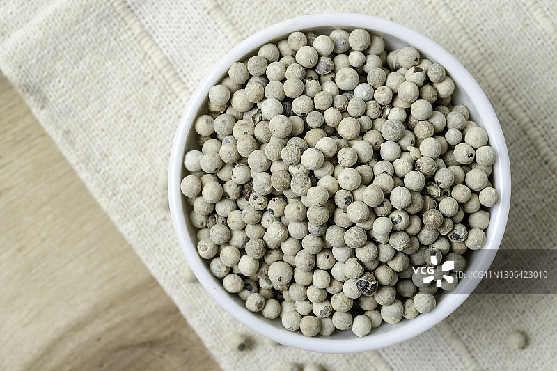 乡村木桌上的陶瓷碗装有机白胡椒图片素材