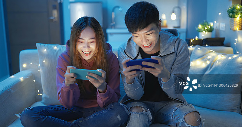 亚洲夫妇玩手机游戏图片素材