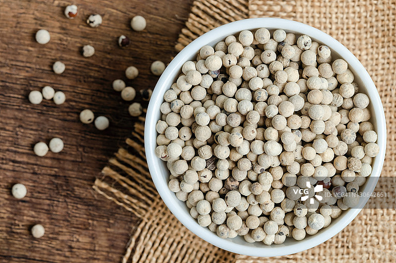 乡村木桌上的陶瓷碗装有机白胡椒图片素材