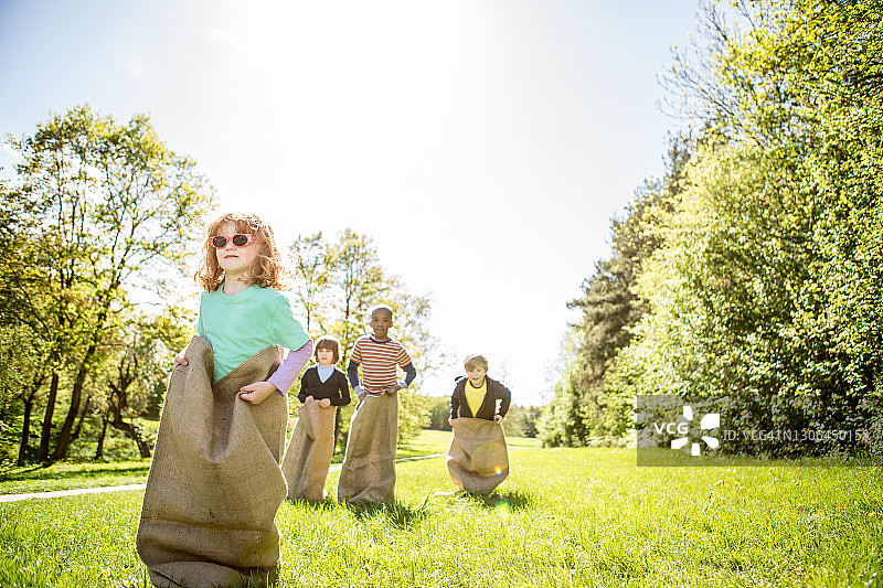 袋子赛跑：一起玩耍的多元种族儿童图片素材
