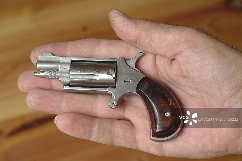 男人拿着袖珍左轮手枪图片素材
