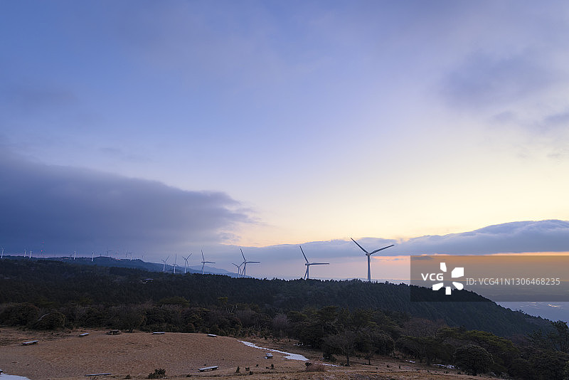 黎明时分山丘上的风力涡轮机图片素材