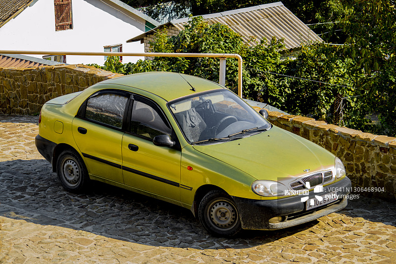 金色ZAZ CHANCE与白色斯巴鲁停在停车场。图片素材