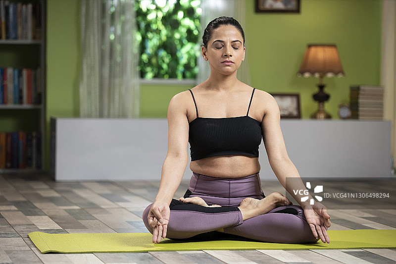 年轻女子在家做运动和瑜伽图片素材