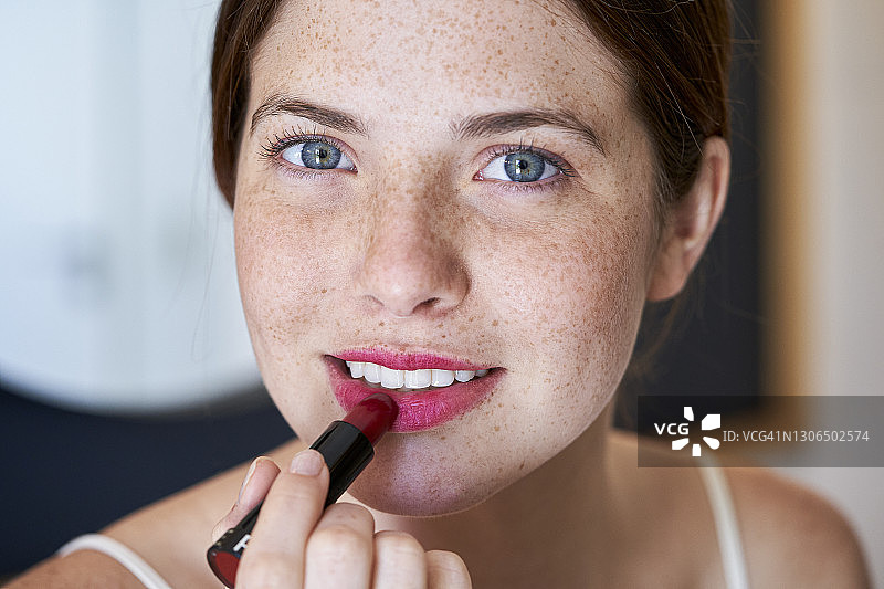 女人在浴室里涂栗色口红图片素材