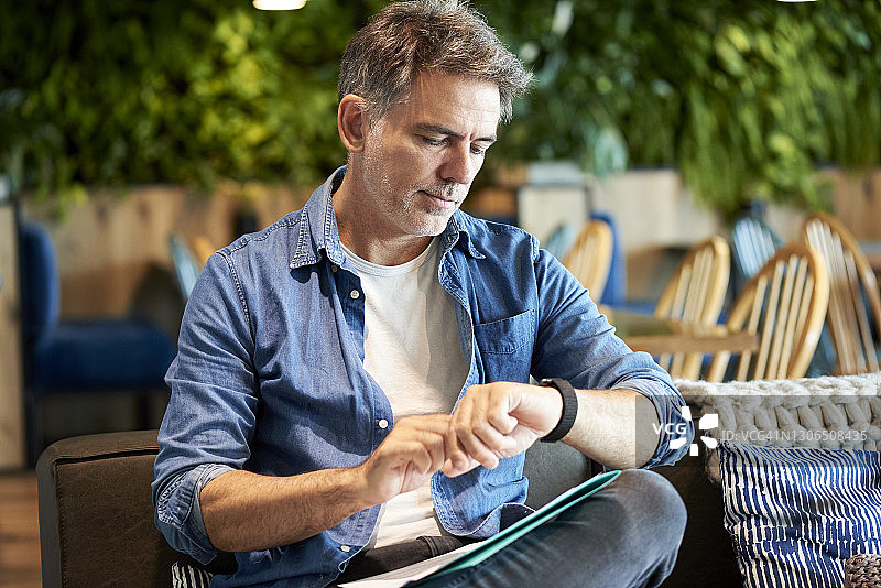 中年男人查看他的手表时间图片素材