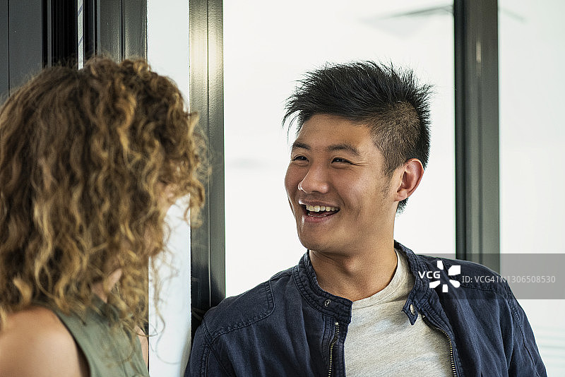 微笑的商人在办公室里和他的同事交谈图片素材