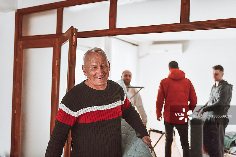 年长的男人在家人的帮助下搬运新床图片素材