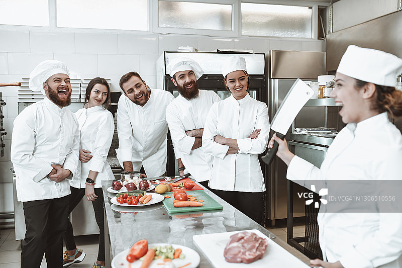 女厨师笑着展示切肉技巧图片素材