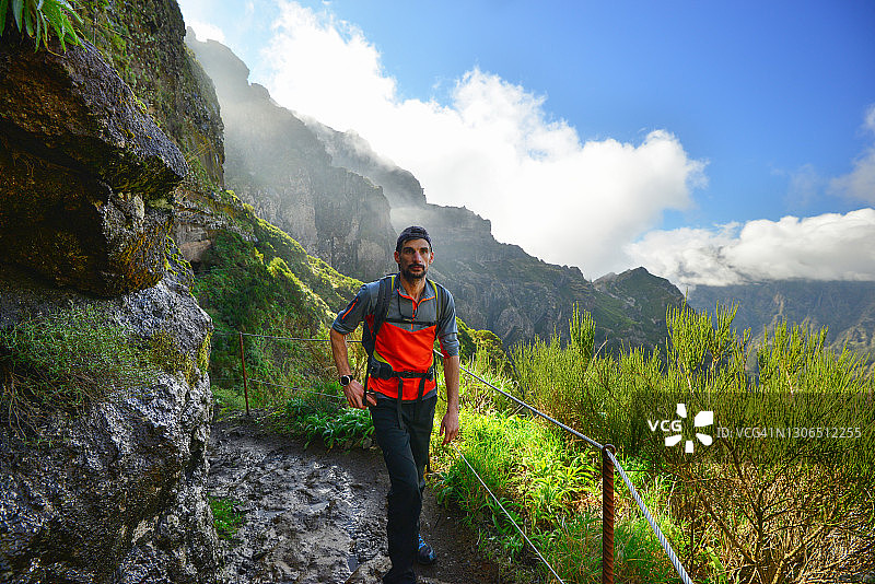 年轻男子在葡萄牙马德拉岛大西洋徒步旅行时在小路上欣赏风景图片素材