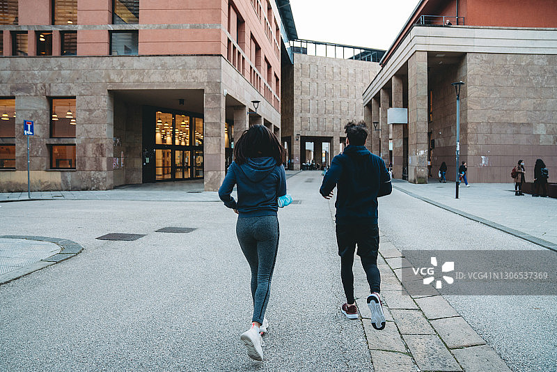 年轻夫妇在城市里一起跑步图片素材