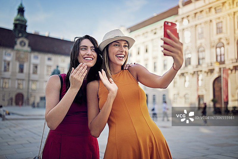 在维也纳市中心进行视频通话的快乐闺蜜图片素材