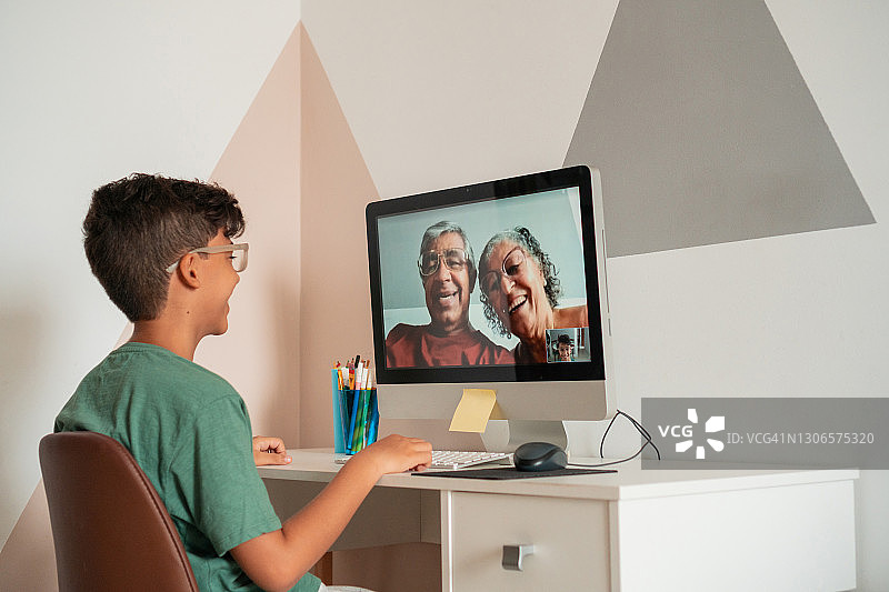 男孩通过视频电话与祖父母交谈图片素材