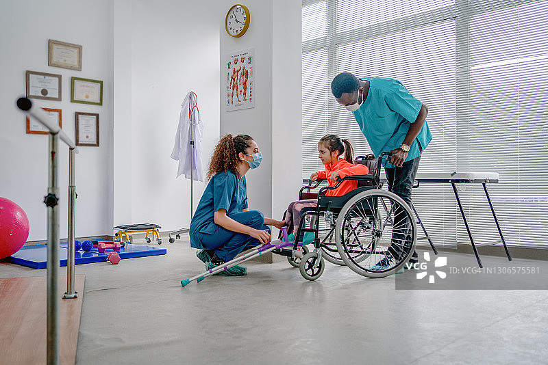 年轻患者在理疗师的帮助下在诊所做理疗图片素材