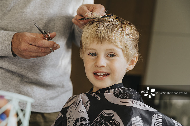 在家理发的金发男孩露出笑容图片素材